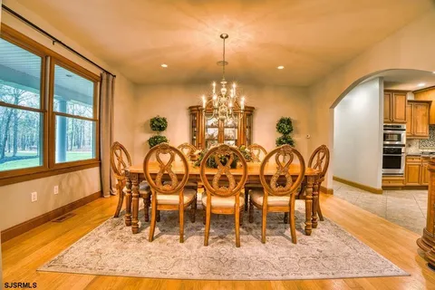 a kitchen with stainless steel appliances granite countertop a sink dishwasher a stove and a refrigerator with wooden floor