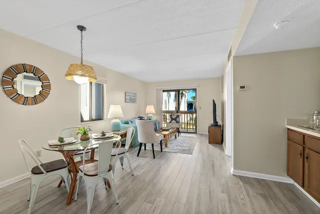 a dining room with furniture a chandelier and wooden floor