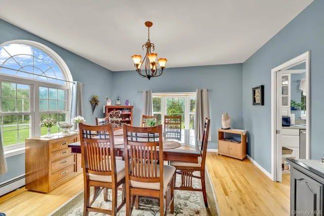 a view of a dining room with furniture a chandelier and wooden floor