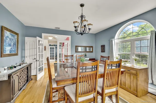 a view of a dining room with furniture a chandelier and wooden floor