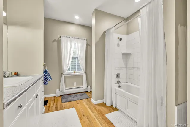 a bathroom with a tub sink and mirror