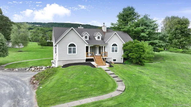 a view of a house with a big yard plants and large trees