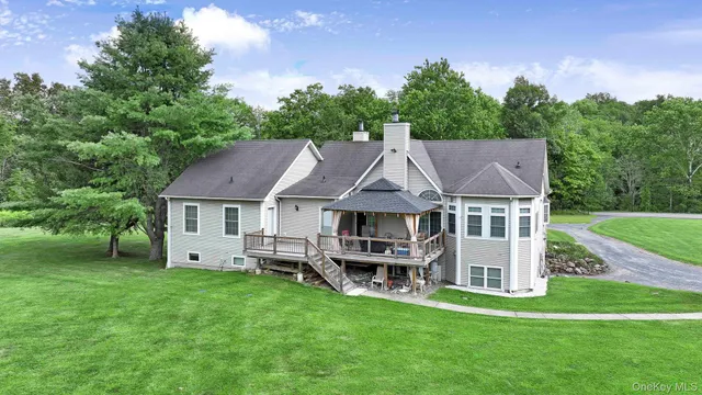 a aerial view of a house with a big yard and large trees