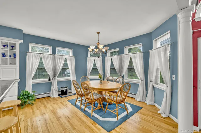a dining room with furniture window and wooden floor