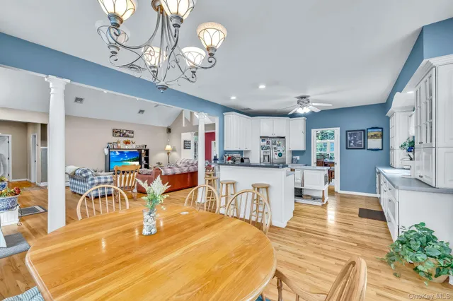 a view of a dining room and livingroom with furniture wooden floor a chandelier