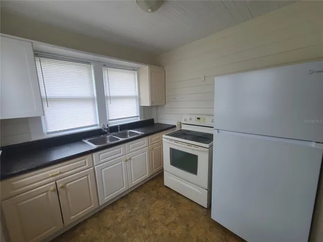 a view of empty room with ceiling fan and window