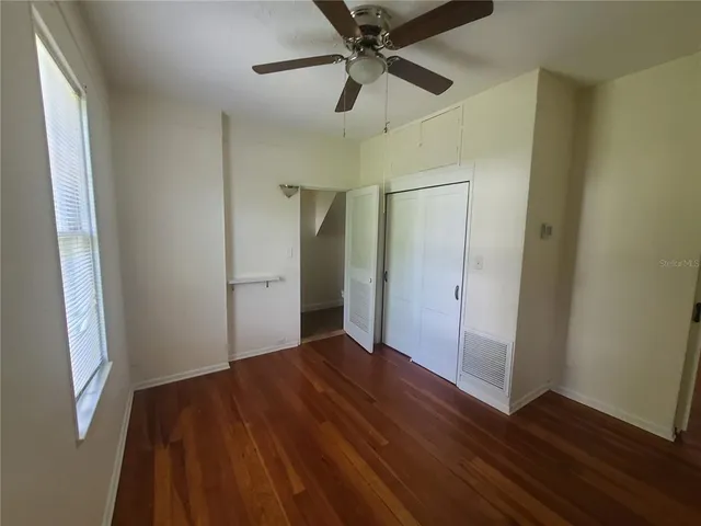 a living room with furniture a bookshelf and a window