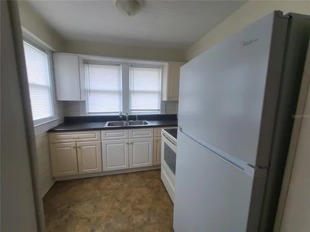 a kitchen with stainless steel appliances granite countertop a refrigerator and a stove