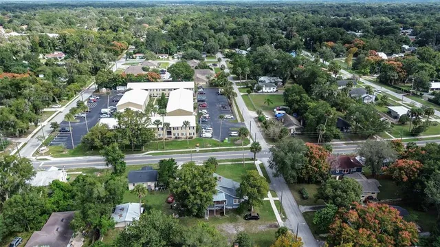 a front view of multi story residential apartment building with yard and green space