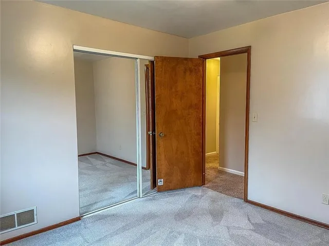 an empty room with closet and a window