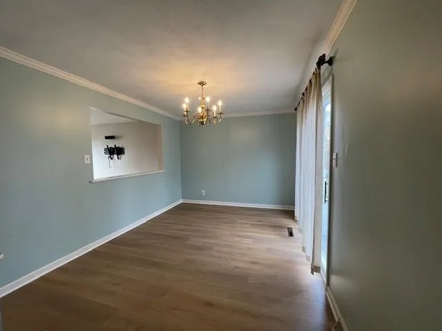 a view of a hallway with a chandelier fan and wooden floor
