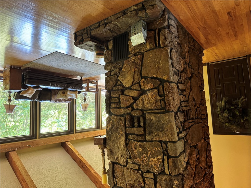 9643 Erbie Cutoff Road South Harrison, AR 72601 - Photo 4 of 41 Floor-to-ceiling stone fireplace feature with a raised hearth, complemented by hardwood flooring, exposed wood beams, and a wall of windows