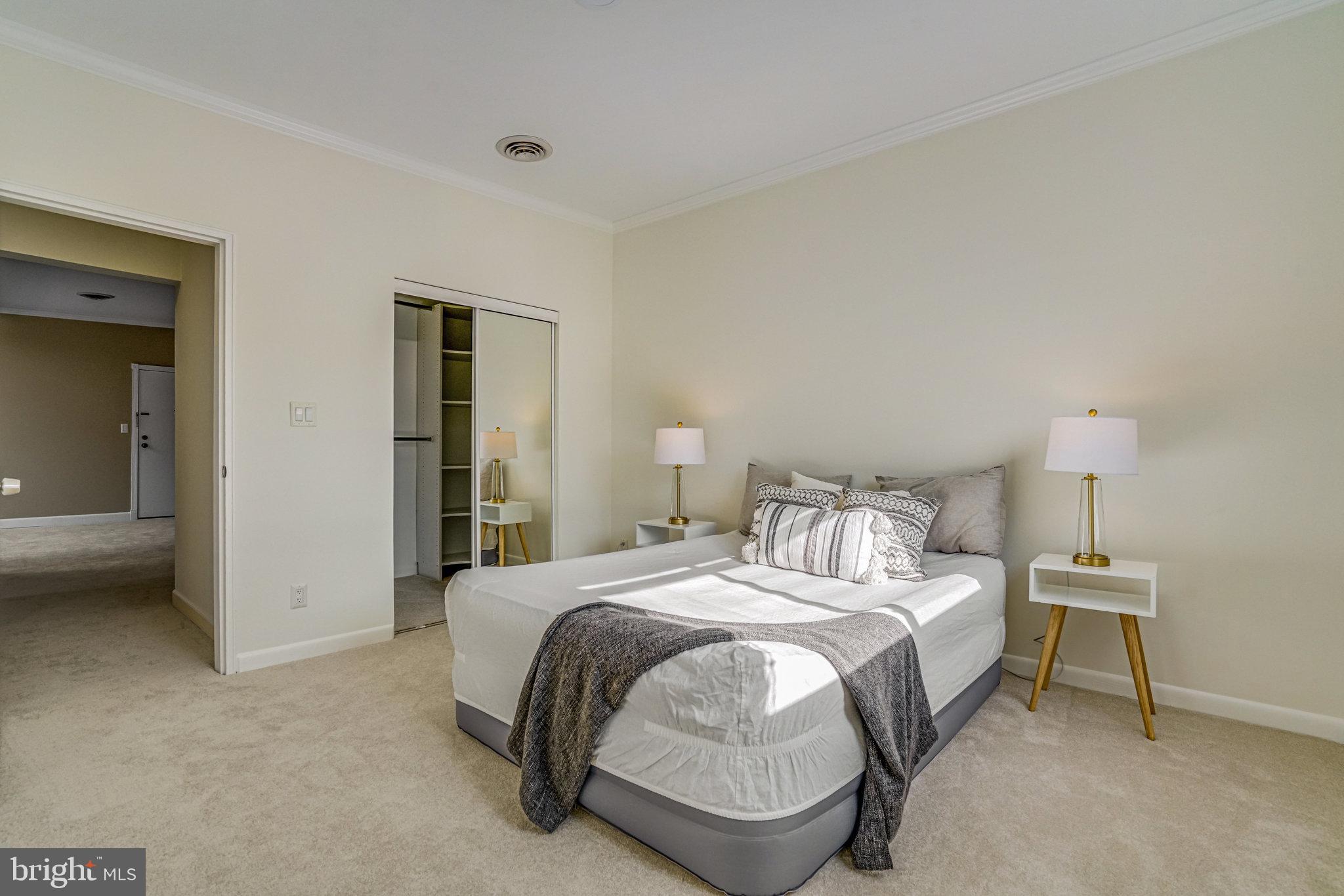 208 Skyhill Road, Unit 10 Alexandria, VA 22314 - Photo 12 of 26 a bedroom with a bed and a view of en suite bathroom