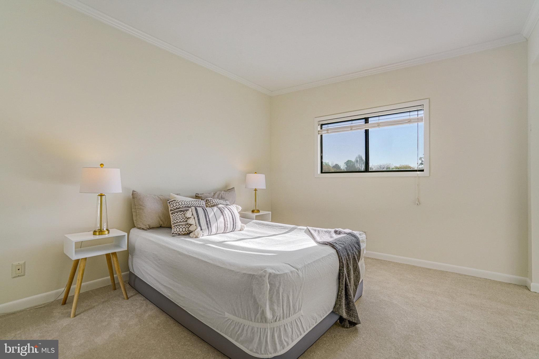 208 Skyhill Road, Unit 10 Alexandria, VA 22314 - Photo 13 of 26 a bedroom with a bed a lamp and a window