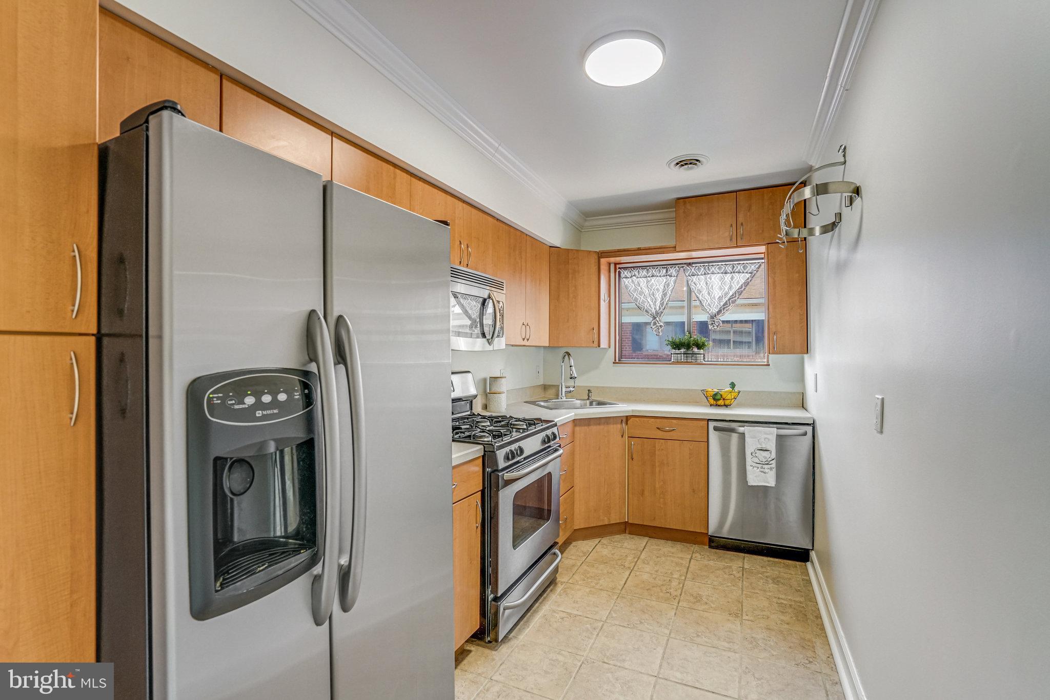 208 Skyhill Road, Unit 10 Alexandria, VA 22314 - Photo 6 of 26 a kitchen with stainless steel appliances granite countertop a refrigerator a stove and a sink with large window