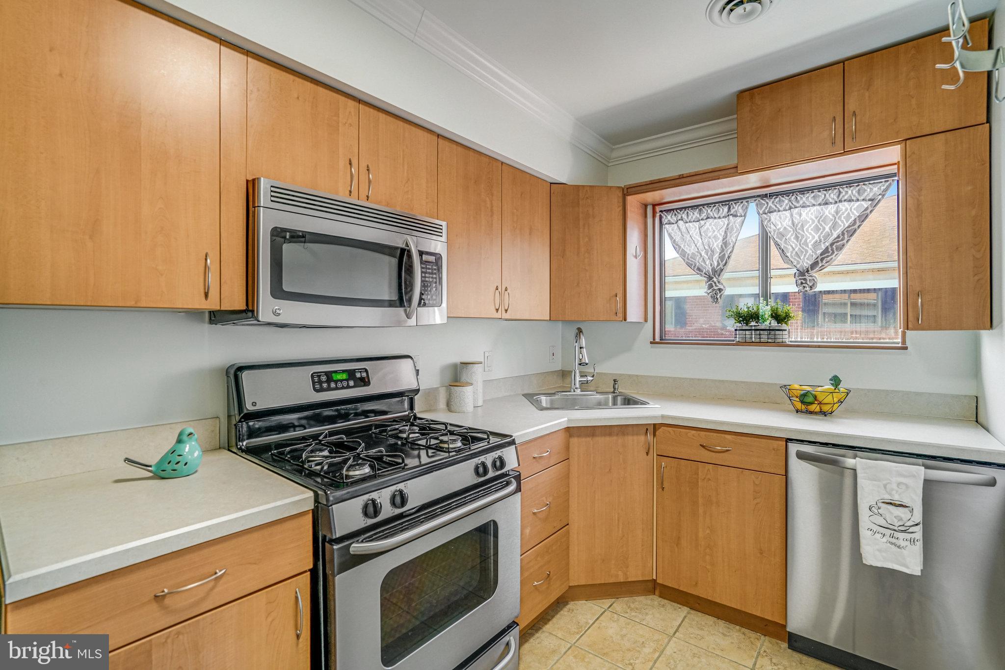 208 Skyhill Road, Unit 10 Alexandria, VA 22314 - Photo 7 of 26 a kitchen with a stove a sink and a microwave