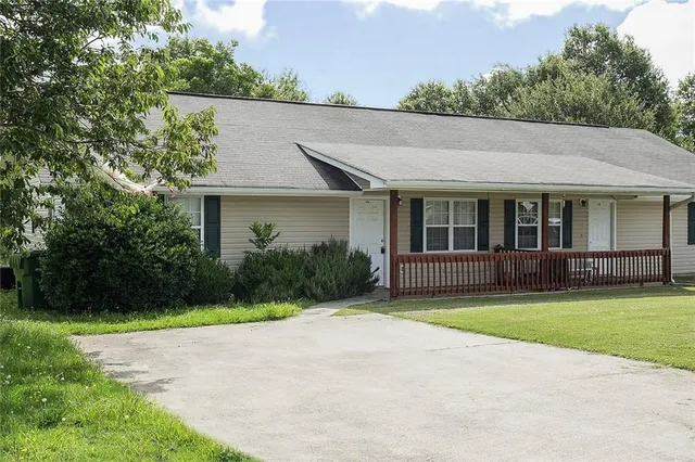 a front view of a house with a garden and yard