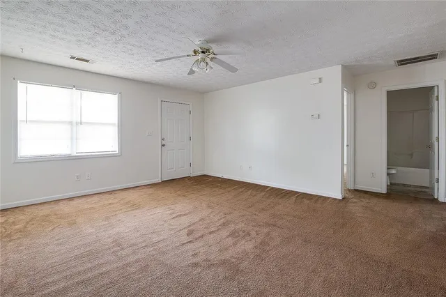 an empty room with chandelier fan