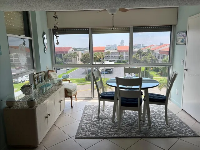 a dining room with furniture and a floor to ceiling window