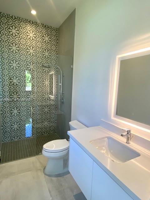 7830 Southwest 117th Street Pinecrest, FL 33156 - Photo 17 of 26 a bathroom with a granite countertop sink a toilet a mirror and shower