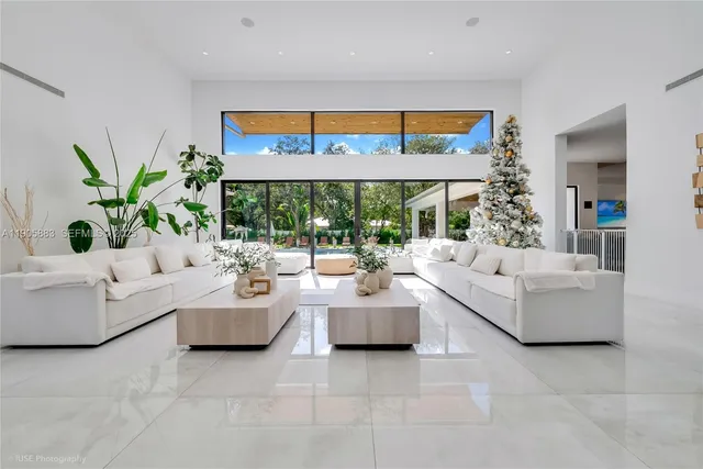 a living room with fireplace furniture and potted plants