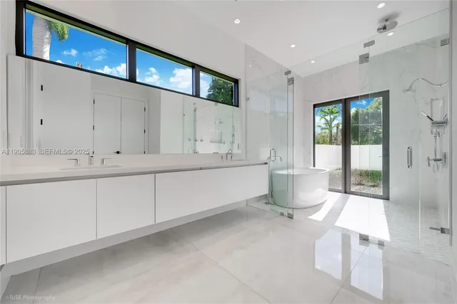a spacious bathroom with a double vanity sink a mirror and a bathtub