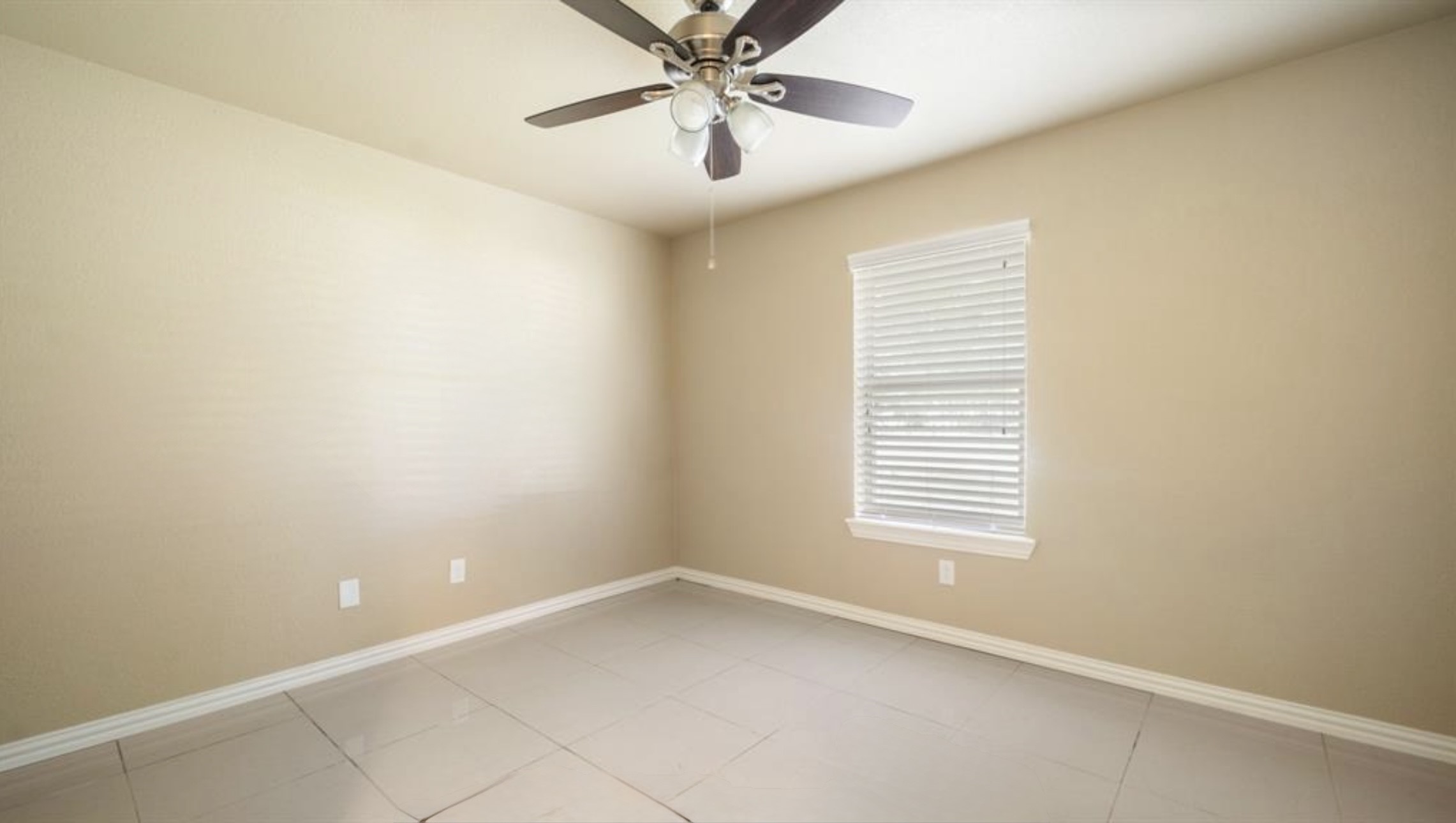 2715 Toyah Avenue Houston, TX 77039 - Photo 15 of 18 Bright and inviting room with modern tile flooring and a sleek ceiling fan. Perfect for a cozy bedroom or home office.