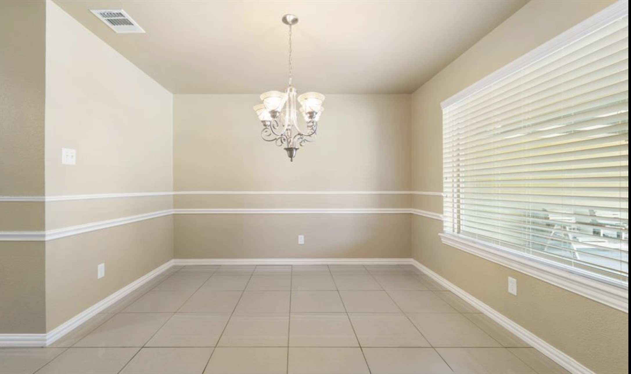 2715 Toyah Avenue Houston, TX 77039 - Photo 5 of 18 Bright and inviting dining area featuring elegant tile flooring, soft neutral tones, and a stylish chandelier. Large window provides ample natural light, creating a warm and welcoming atmosphere.