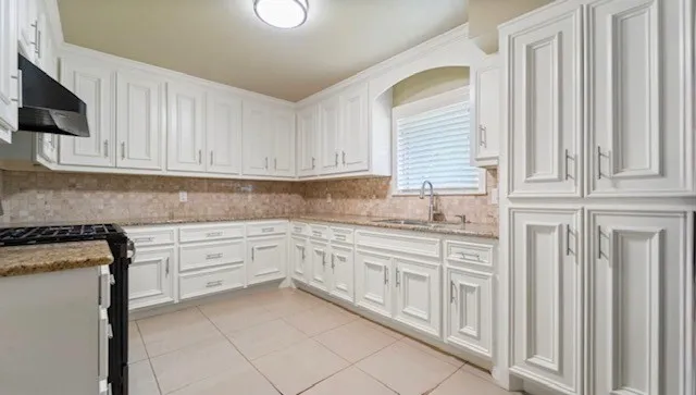 a kitchen with granite countertop white cabinets and white appliances