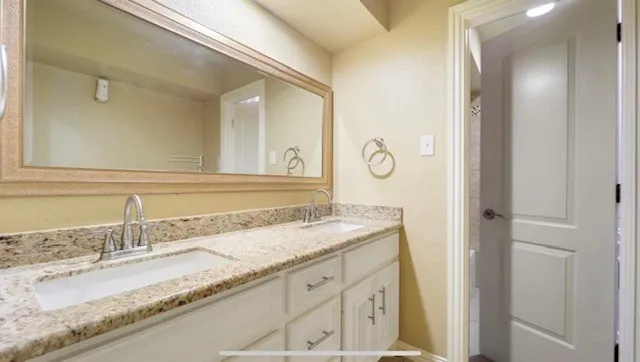 a bathroom with a granite countertop sink and a mirror