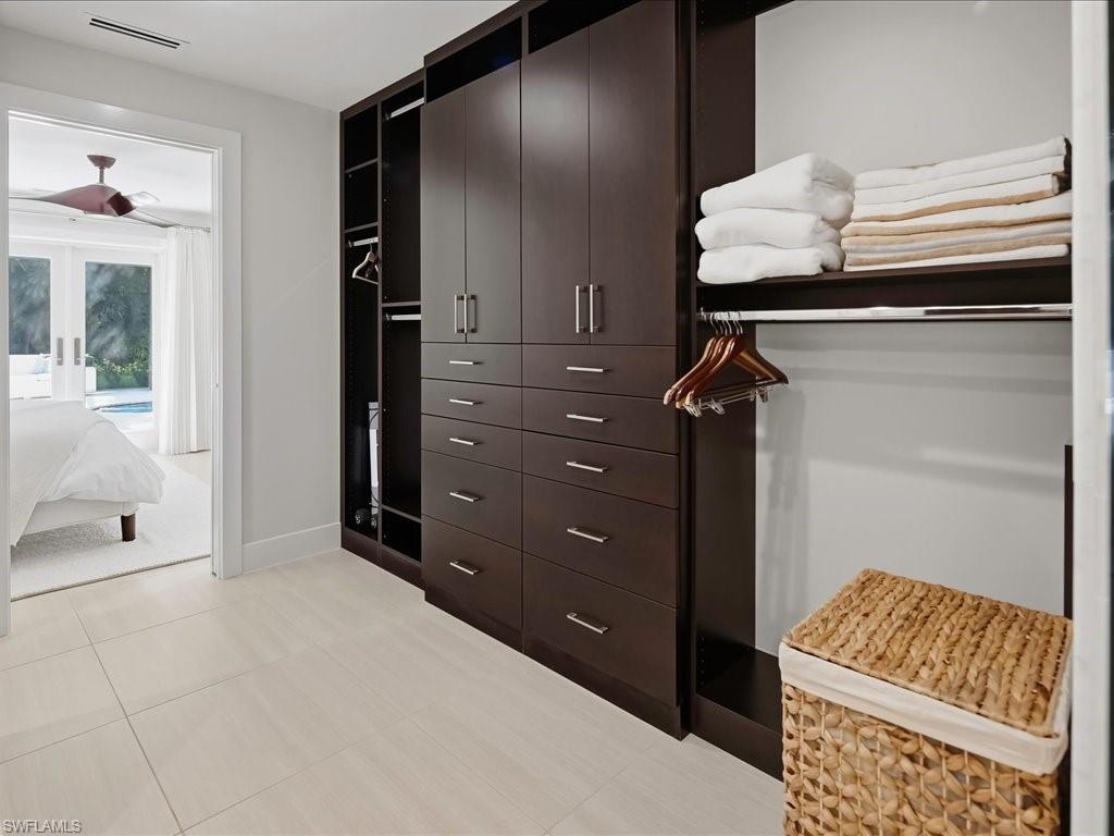 1390 Mandarin Road Naples, FL 34102 - Photo 37 of 50 Custom wood-finish closet system with ample storage, drawers, and shelving