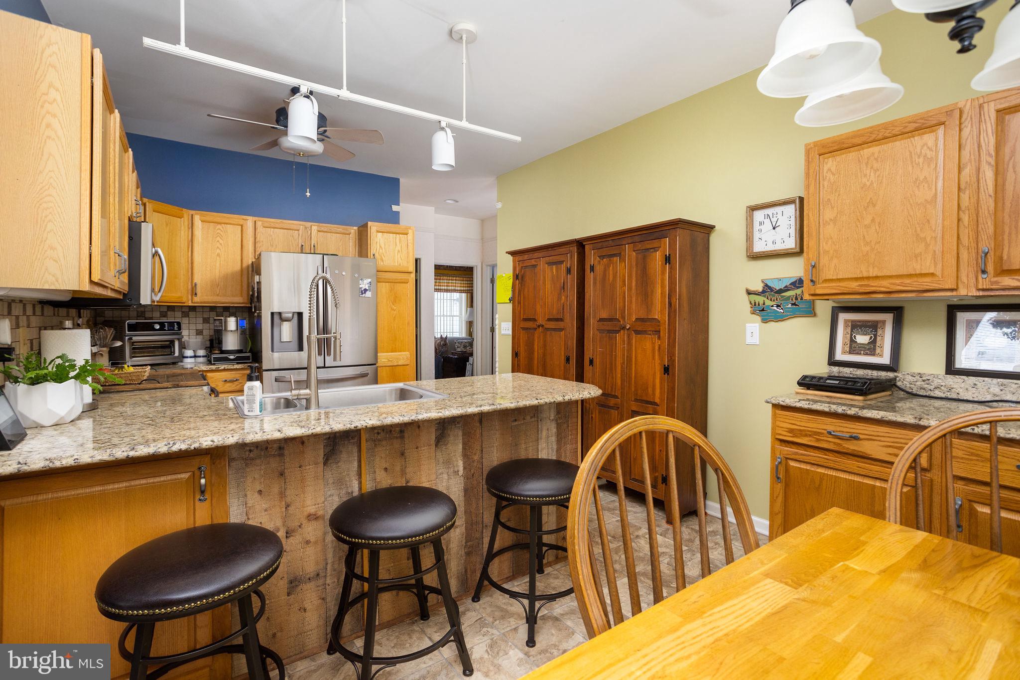 4 Lantern Lane Columbus, NJ 08022 - Photo 16 of 46 a kitchen with stainless steel appliances granite countertop a table chairs in it and wooden floors