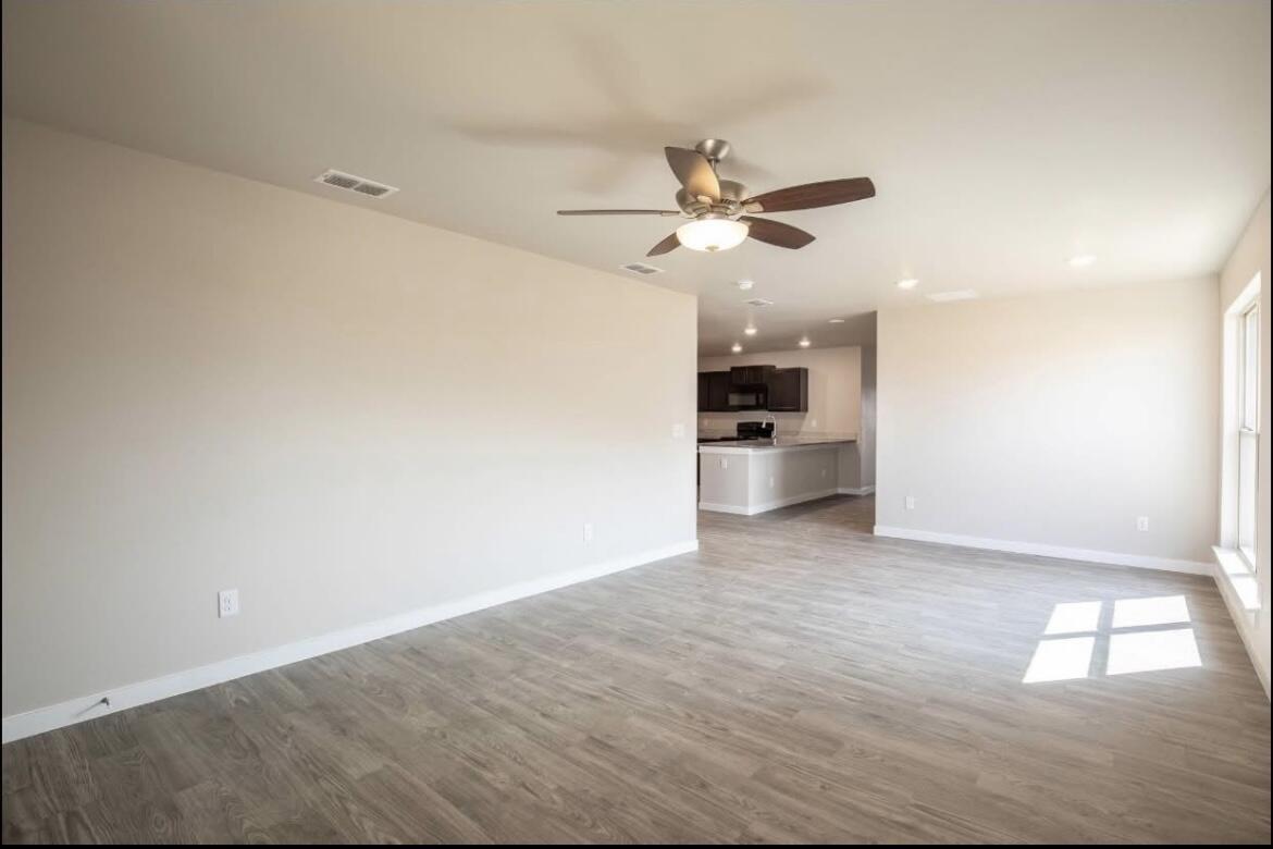 2410 144th Street, Unit 12 Lubbock, TX 79423 - Photo 3 of 13 a view of a big room with wooden floor and a kitchen