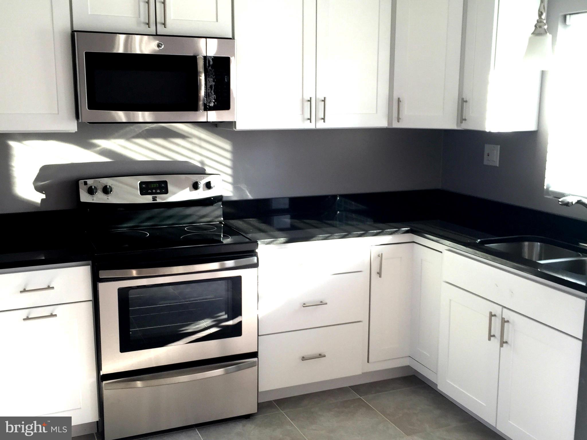 9911 Old Fort Road Fort Washington, MD 20744 - Photo 2 of 25 a kitchen with a stove and microwave