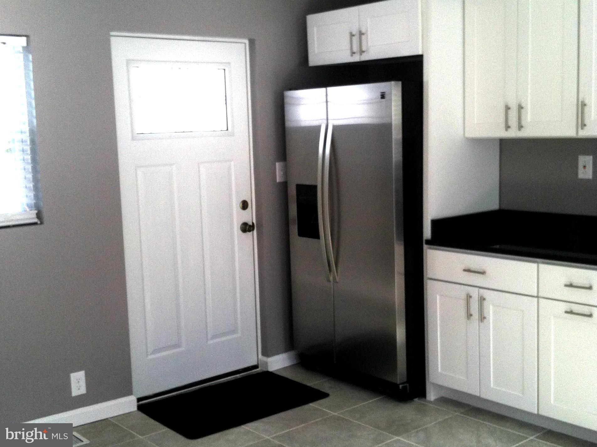 9911 Old Fort Road Fort Washington, MD 20744 - Photo 24 of 25 a close view of a refrigerator in kitchen and white cabinets