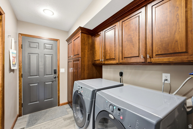 2073 Village Point Way Sandy, UT 84093 - Photo 32 of 68 Dedicated laundry area on main level featuring wood-finish cabinetry, built-in storage, and light wood-finish flooring.