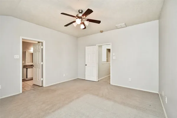 an empty room with chandelier fan