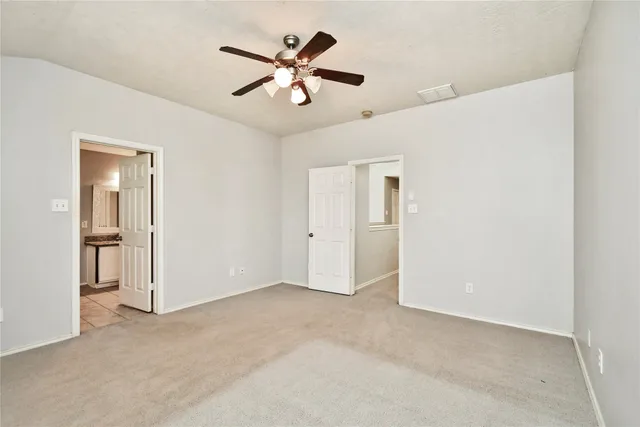 an empty room with chandelier fan