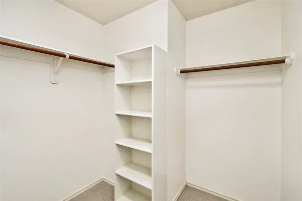 a view of walk in closet with empty racks