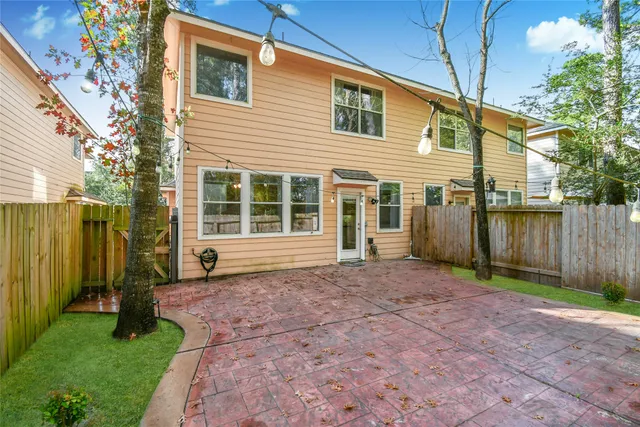 a view of a house with backyard and a tree