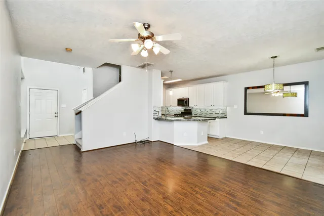 a view of a kitchen with wooden floor and a ceiling fan