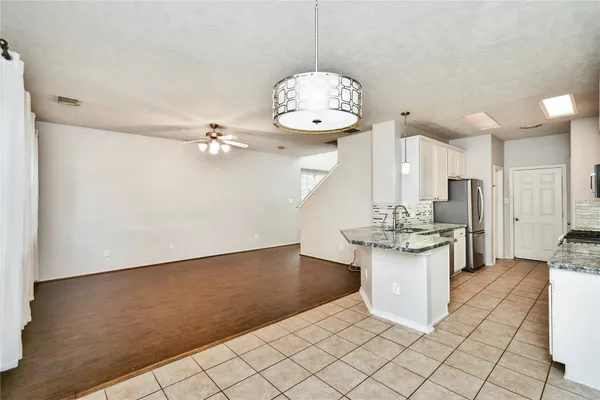 a view of a kitchen with a sink and chandelier