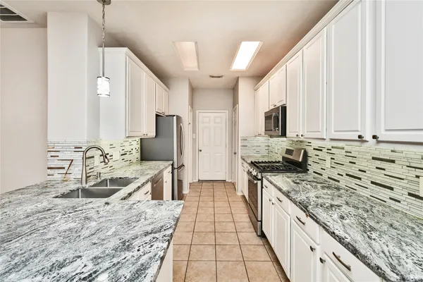 a large kitchen with kitchen island granite countertop a sink stove and refrigerator