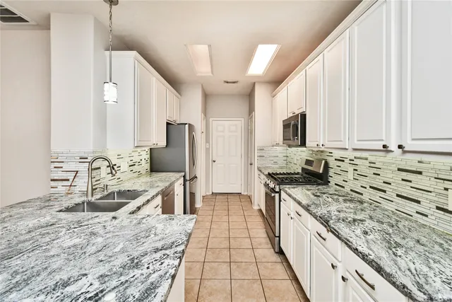 a large kitchen with kitchen island granite countertop a sink stove and refrigerator