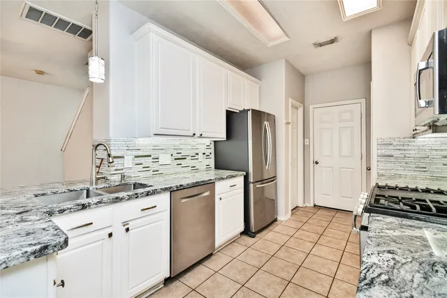 a kitchen with a refrigerator sink stove and cabinets