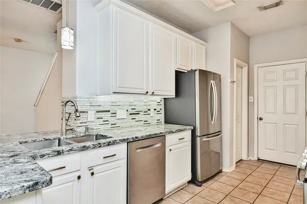 a kitchen with stainless steel appliances granite countertop a refrigerator sink and cabinets