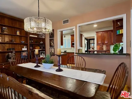 a view of a dining room with furniture a chandelier and wooden floor