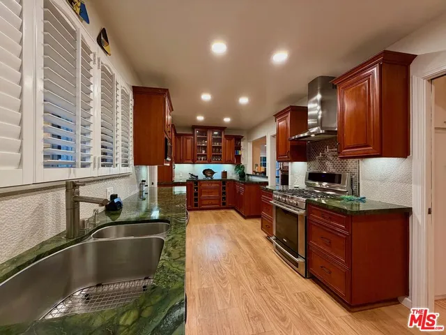 a kitchen with stainless steel appliances granite countertop a stove a sink dishwasher and a refrigerator