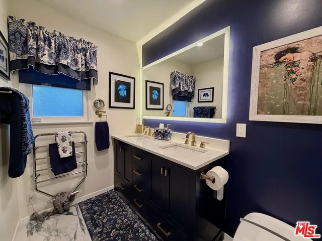 a white toilet sitting next to a bathroom sink and a shower