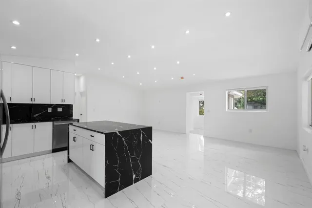 a kitchen with a sink a refrigerator and cabinets